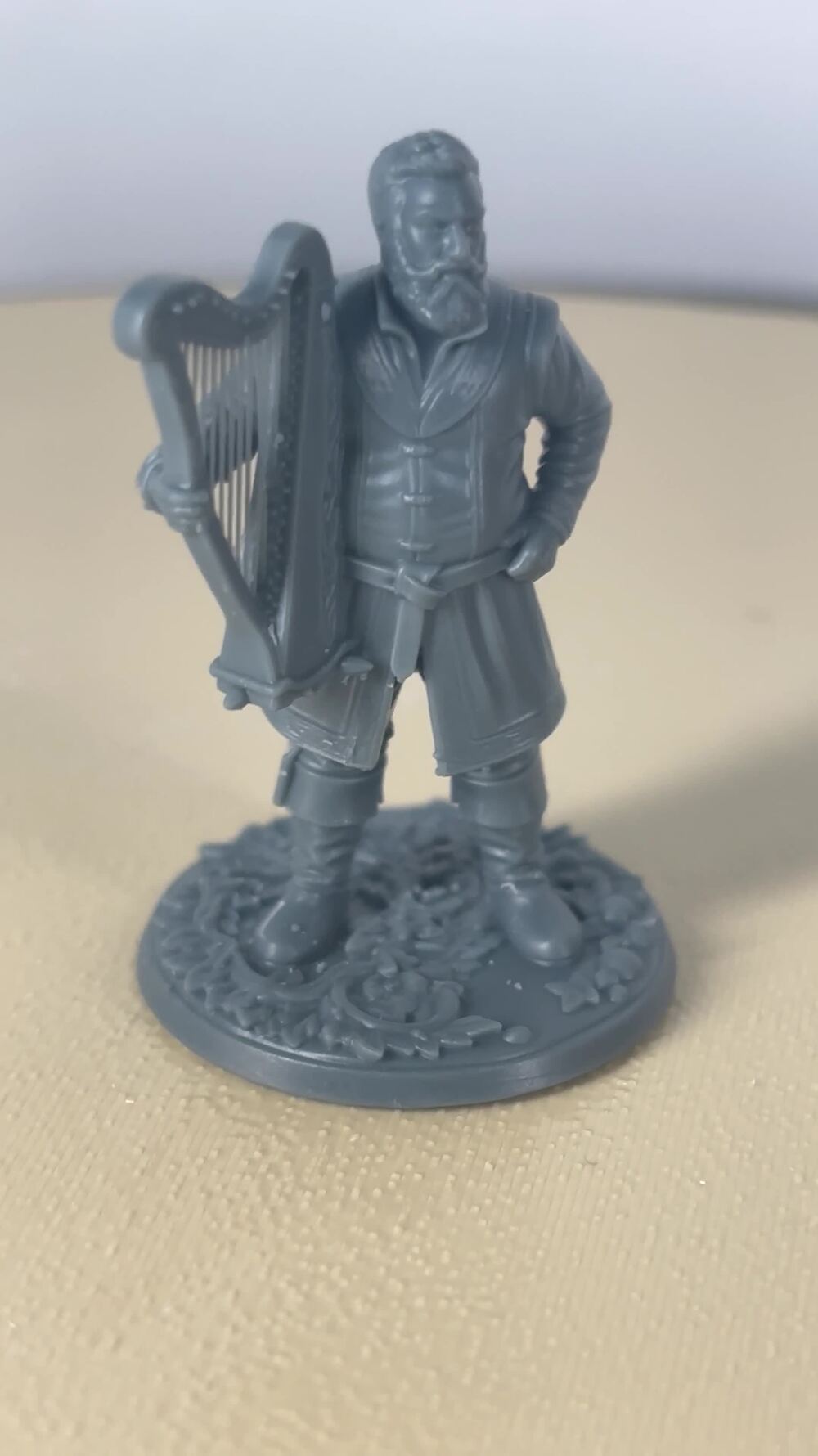 Printed miniature of a bard character with a harp